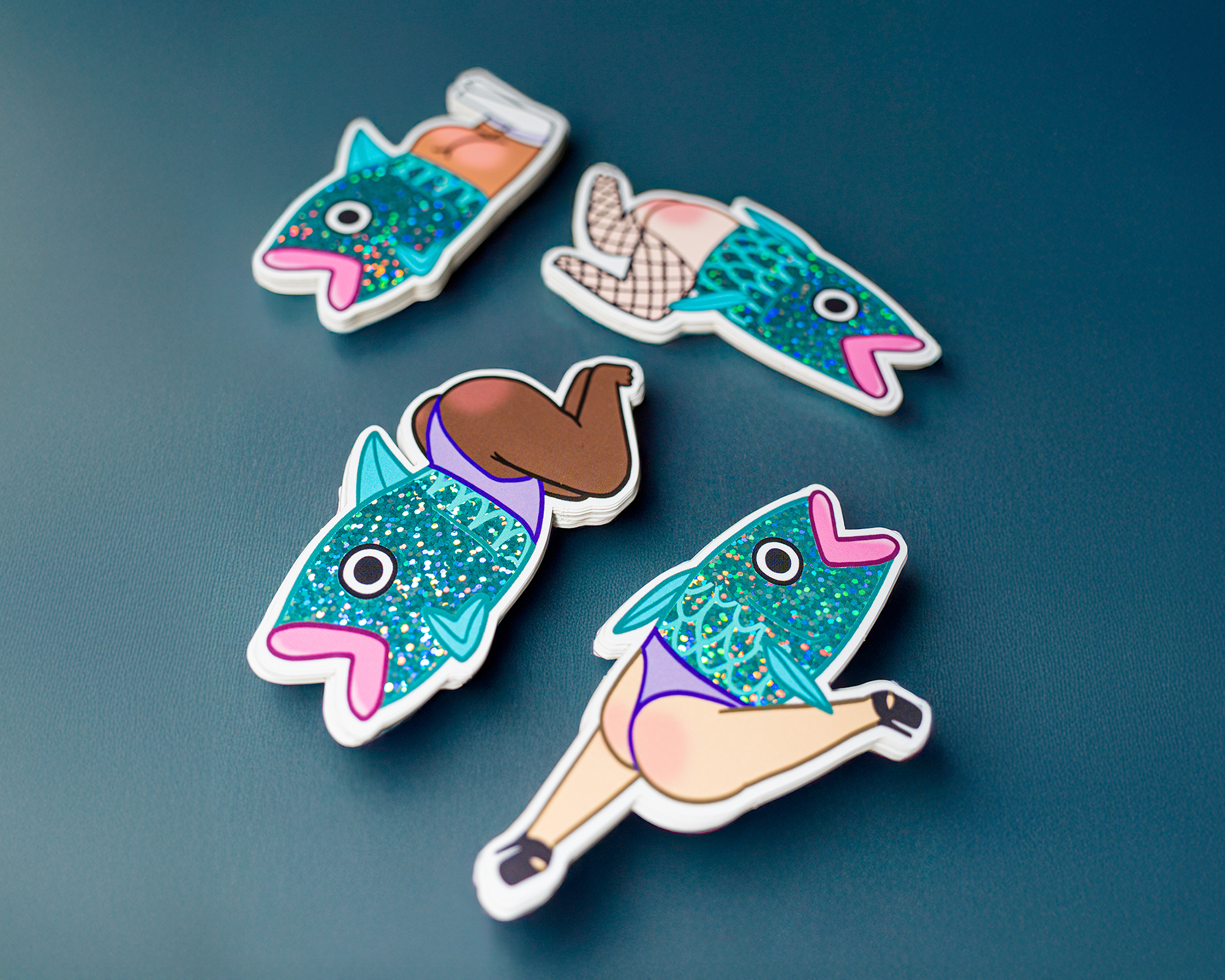 Vier bunte Aufkleber mit Fischen, die menschliche Beine in Strumpfhosen und Unterwäsche haben, auf blauem Hintergrund.
